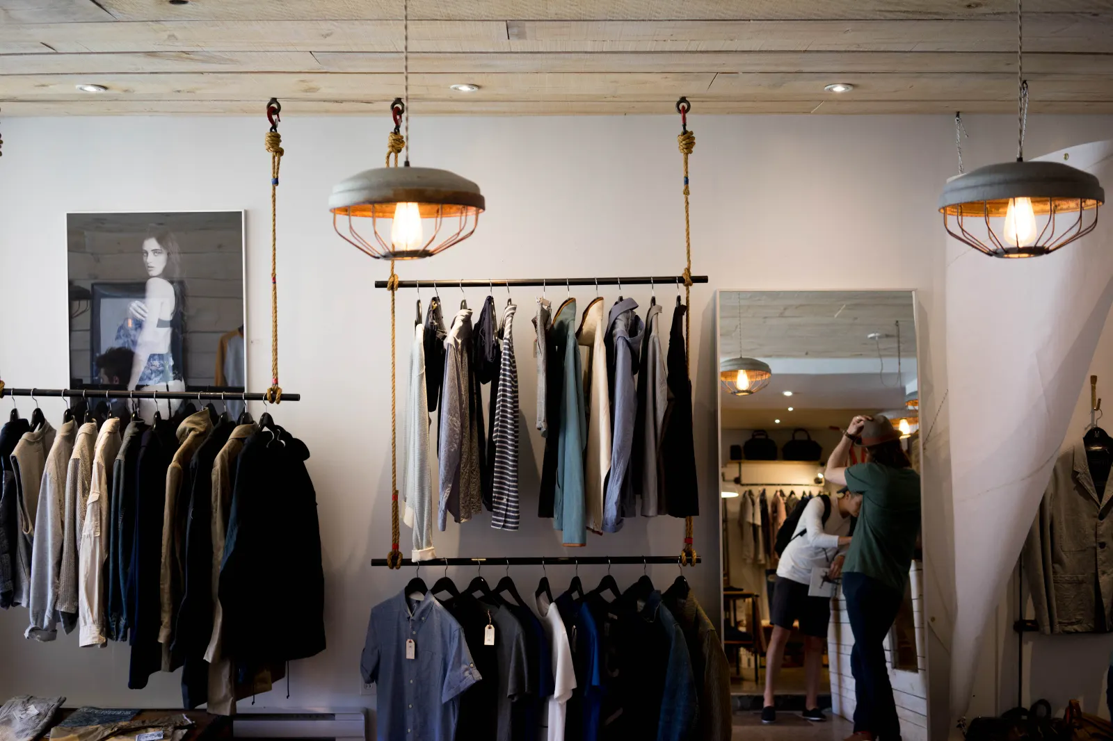 A quiet boutique with garments on a rail beside a window.